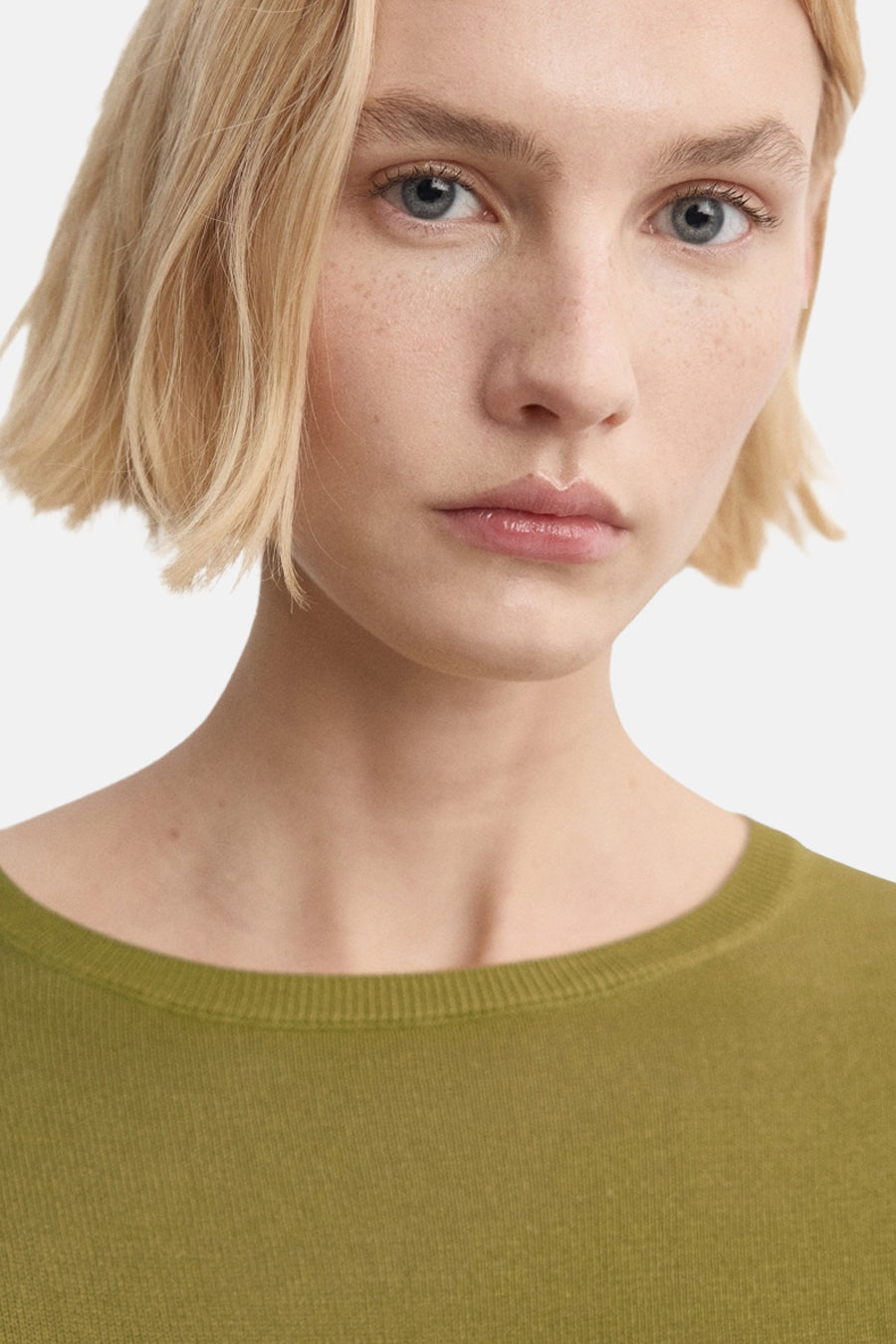 Kaki trui van MANGO, gedragen door een model met een lichte huidskleur en kort blond haar.