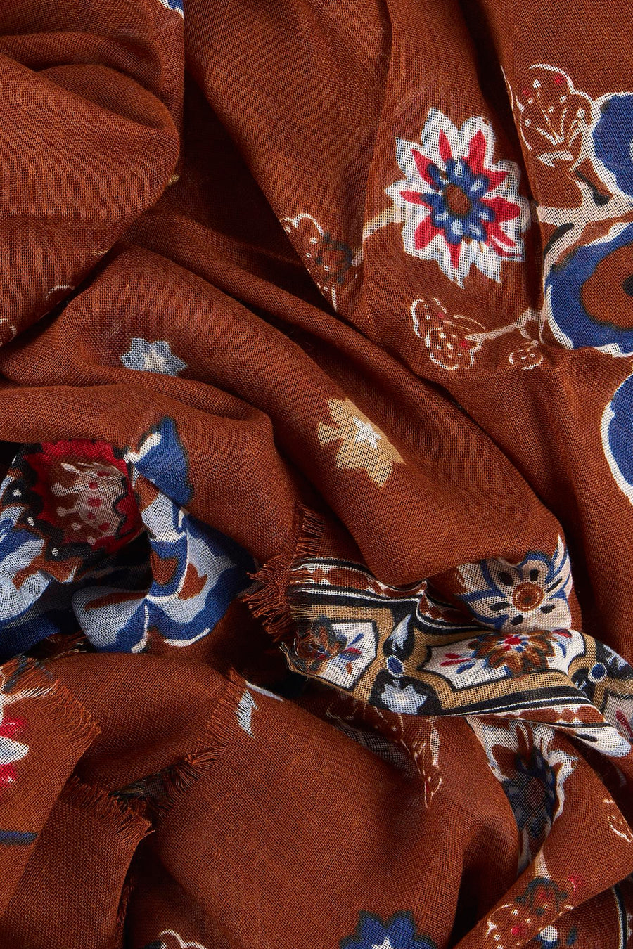 Foulard multicolore de MANGO, avec un motif fleuri et oriental sur un tissu froissé brun.
