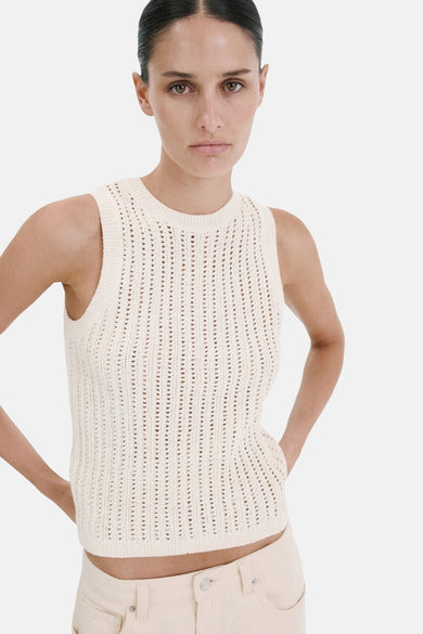Top sans manches écru de MANGO en maille ajourée à col rond, porté avec un pantalon clair.