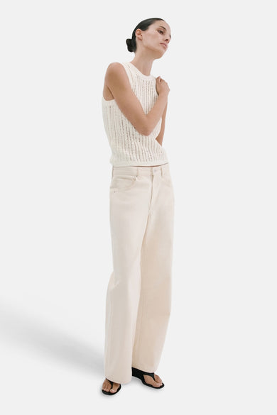 Top sans manches écru de MANGO en maille ajourée, porté avec un pantalon large et des sandales.