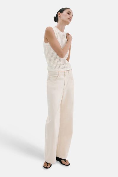Top sans manches écru de MANGO en maille ajourée, porté avec un pantalon large et des sandales.