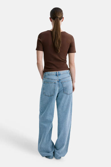 T-shirt marron côtelé à manches courtes de MANGO, porté de dos avec un jean bleu clair.