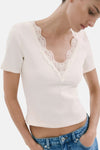 Ecru T-shirt met korte mouwen van MANGO, geribd, aansluitend, achterkant met een blauwe jeans.