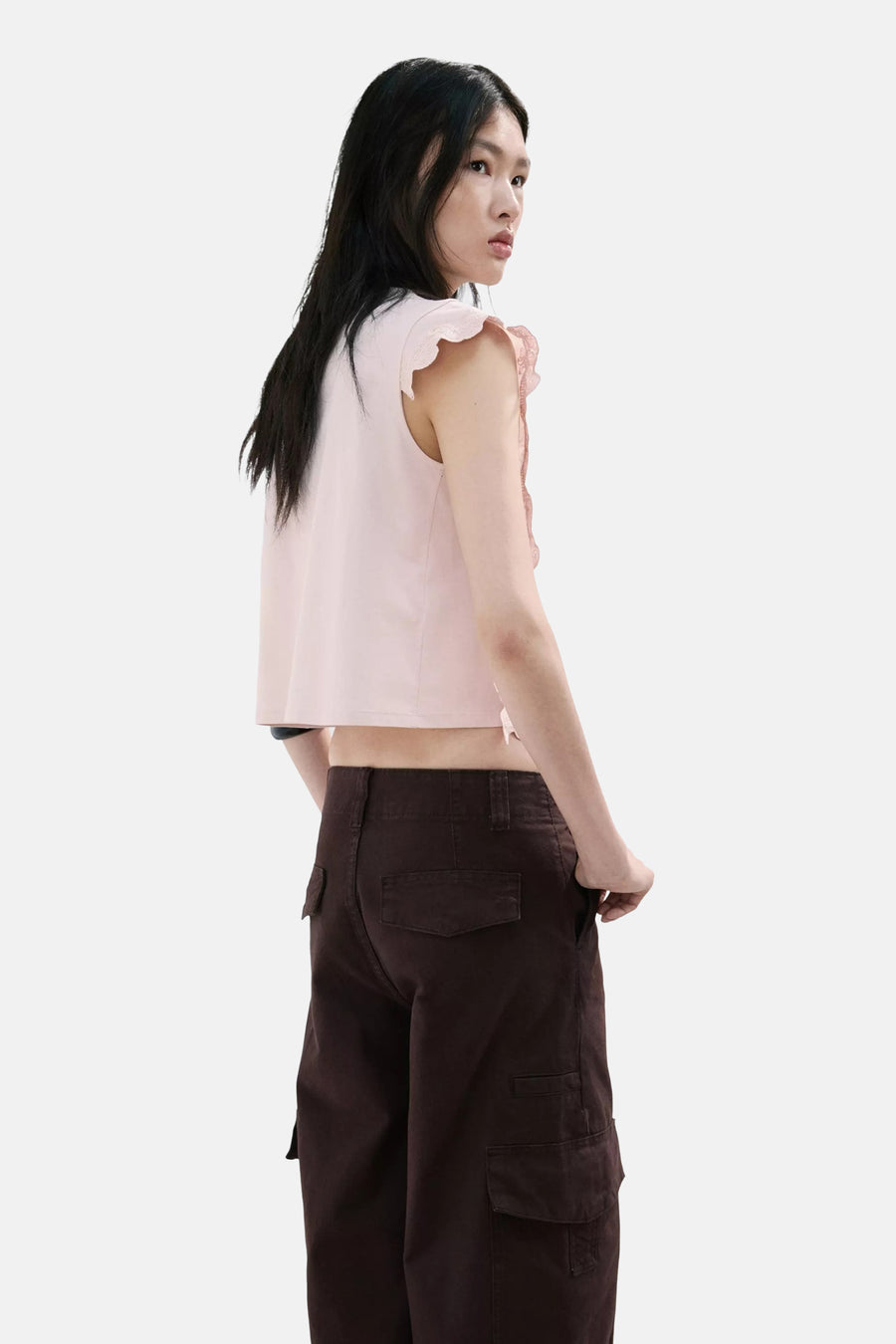 Blouse sans manches rose de MANGO à volants en dentelle, coupe courte, portée avec un pantalon cargo marron.
