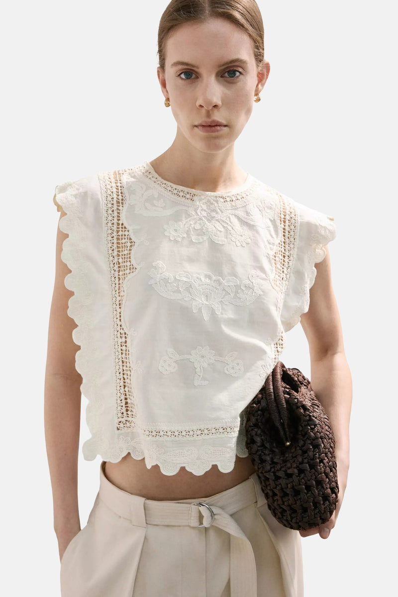 Beige MANGO blouse met korte, kanten ruchesmouwen, van achteren gedragen met een beige wijde cargobroek.
