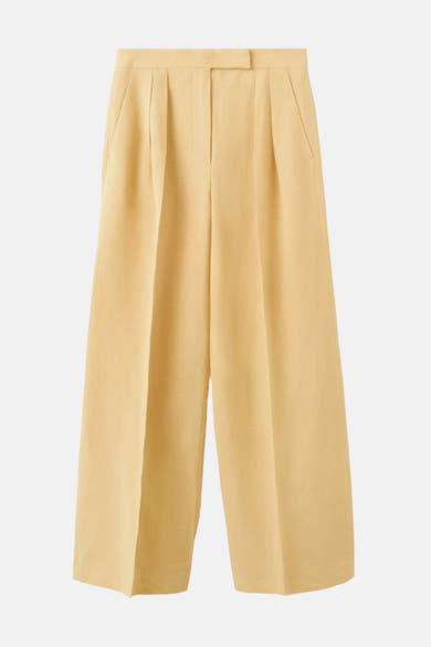 Pantalon jaune de MANGO, coupe ample avec des plis sur le devant et poches latérales.