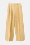 Pantalon jaune de MANGO, coupe ample avec des plis sur le devant et poches latérales.