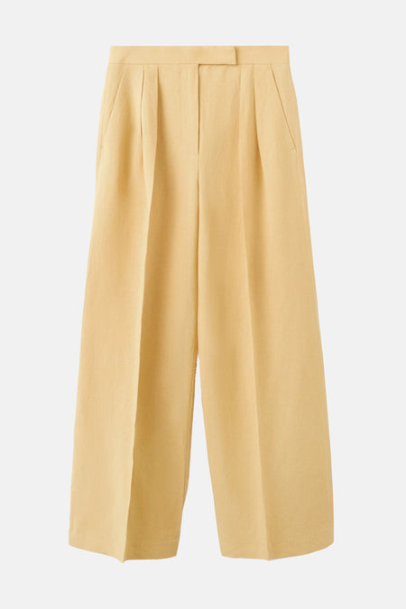 Pantalon jaune de MANGO, coupe ample avec des plis sur le devant et poches latérales.