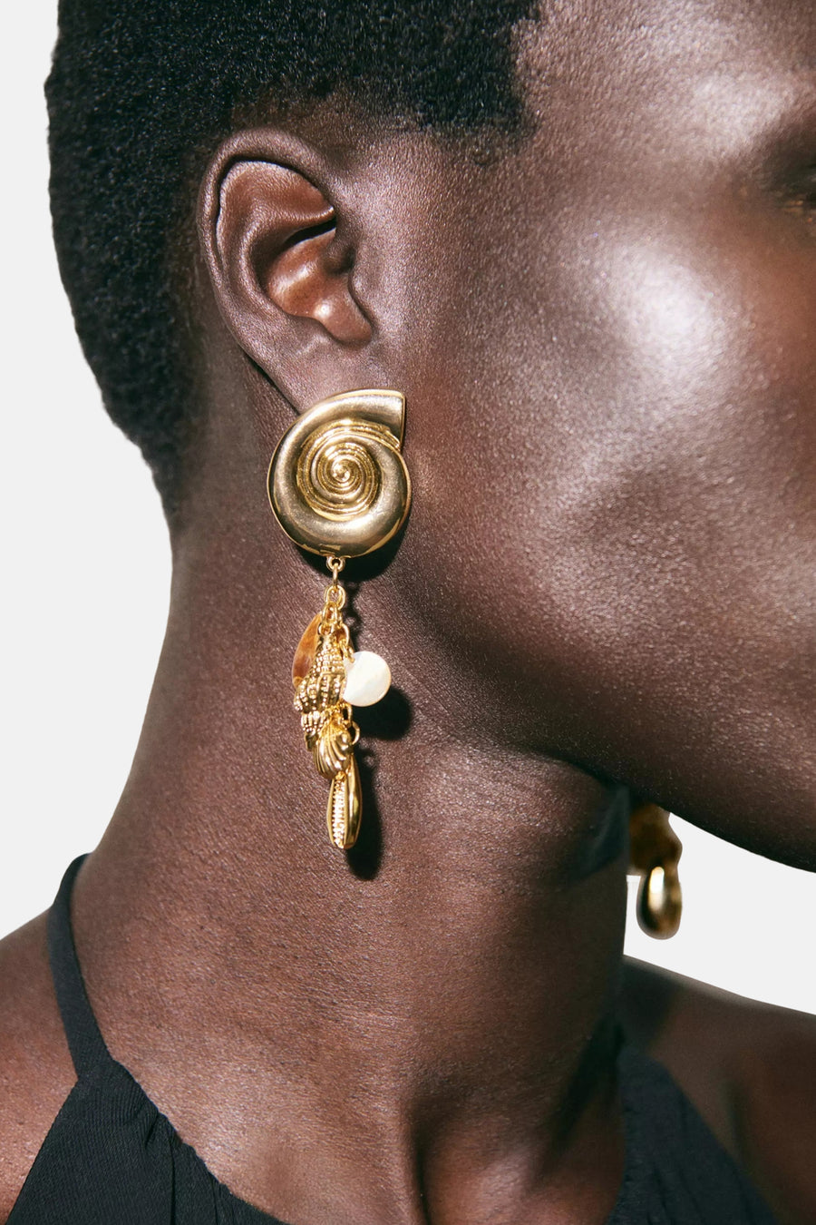 Boucles d'oreilles multicolores de MANGO, avec spirale dorée et pendentifs coquillages, perle et breloque ambrée.