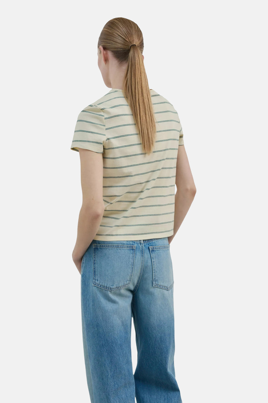 T-shirt jaune à manches courtes de MANGO avec des rayures fines vertes, porté de dos avec un jean.