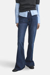 Donkerblauwe flared jeans van MANGO, achterkant, gedragen met een lichtblauw overhemd en een grijze trui.