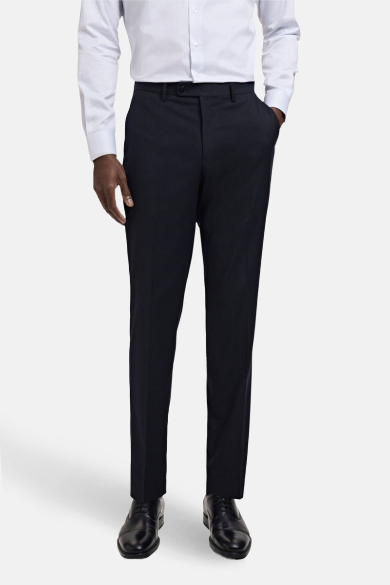Blauwe pantalon van MANGO, slim fit, met knoopzakken achter, gedragen met een wit overhemd.