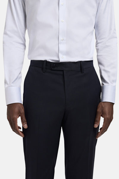 Blauwe pantalon van MANGO, gedragen met een wit en blauw gestreept overhemd.