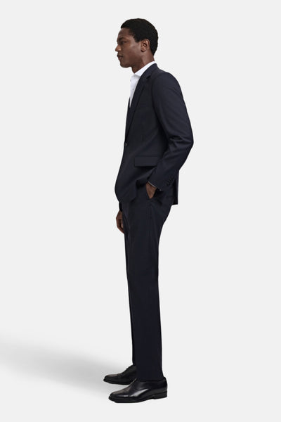 Blauwe pantalon van MANGO, slim fit met zijzakken en zwarte schoenen.