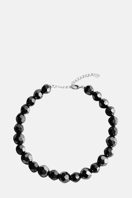 Collier court noir à perles taillées de MANGO, avec une chaîne de réglage argentée.
