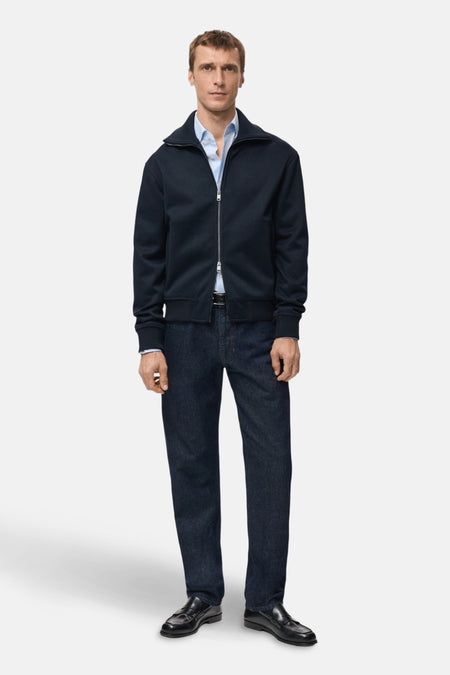 Blauwe trui met klap van MANGO, gedragen over een lichte blauwe shirt en een donkere broek.