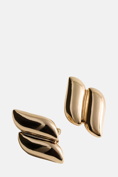 Gouden oorbellen van MANGO, sculpturaal ontwerp met een glanzende afwerking.