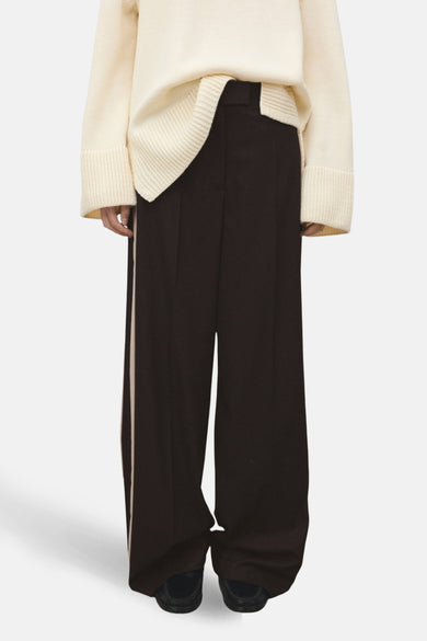 Bruine broek met crèmekleurige strepen van MANGO, gedragen met een wollen trui, achtergezicht.