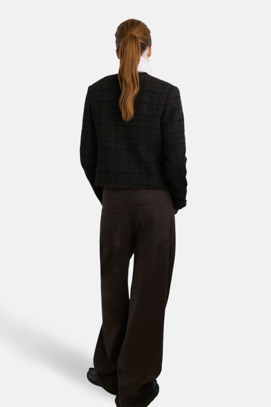 Veste marron à carreaux par MANGO, portée avec un col roulé blanc et un pantalon marron taille haute, vue de dos.