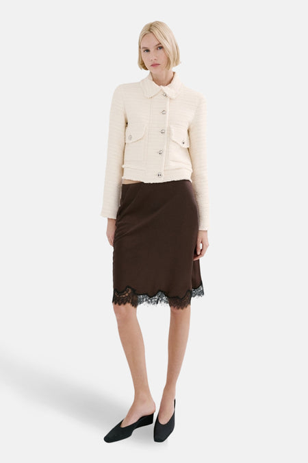 Ecru blazer van MANGO met opgestikte zakken en gedragen met een bruine rok met zwarte kanten details.