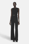 Zwarte jumpsuit van MANGO, met een dunne riem, wijde pijpen en blote rug.