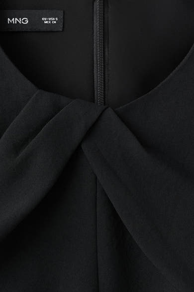 Zwarte jumpsuit van MANGO, met V-hals en zichtbare ritssluiting.