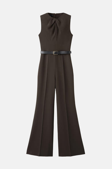 Bruin jumpsuit van MANGO, met een zwarte riem met gouden gesp en uitlopende pijpen.