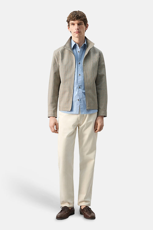 Veste courte multicolore de MANGO, à carreaux, portée sur une chemise bleue et un pantalon beige.
