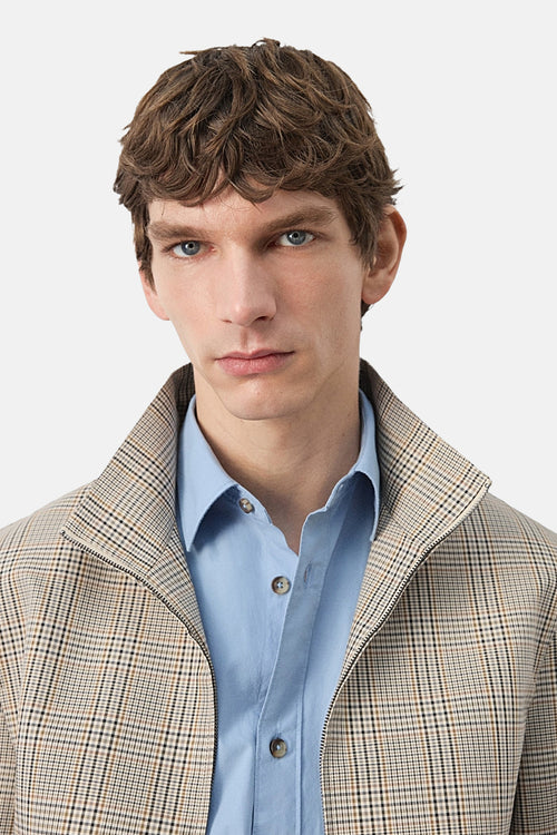 Veste courte multicolore de MANGO avec motif à carreaux et fermeture éclair visible, portée sur une chemise bleu clair.