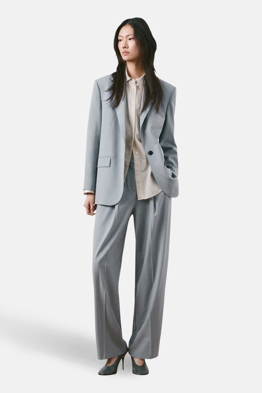 Blauwe pantalon van MANGO, rechte pasvorm, gedragen met een gestreept overhemd en pumps.