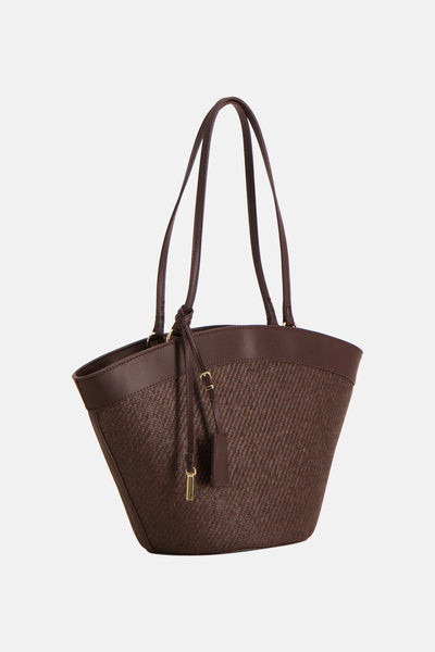 Sac à bandoulière brun de MANGO avec un corps tissé, des poignées doubles et une étiquette décorative.