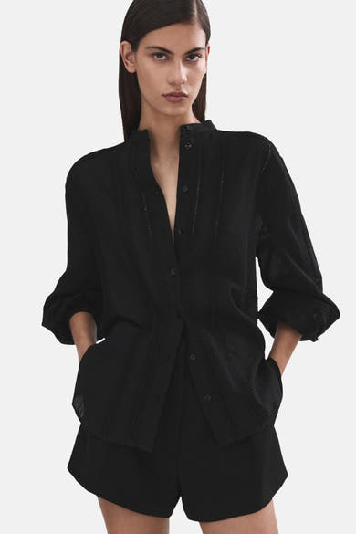 Chemisier noir à manches longues de MANGO, avec détails brodés et coupe décontractée.