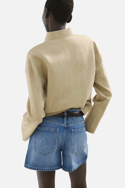 Bermuda en denim bleu moyen de MANGO, avec ceinture marron et poches arrière carrées.