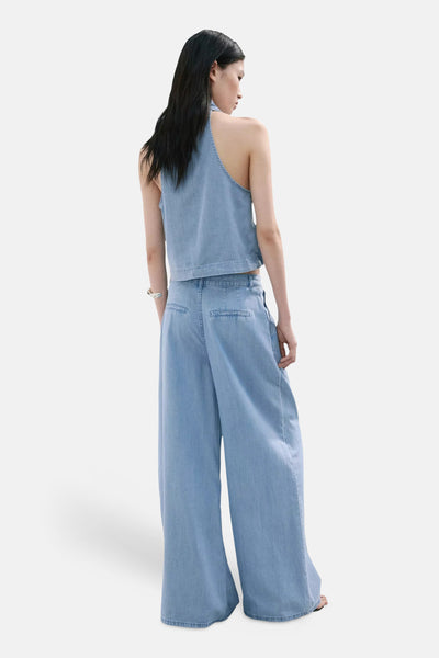 Light blue wide-leg denim pants from back view, featuring clean stitching and relaxed fit, paired with matching sleeveless top.