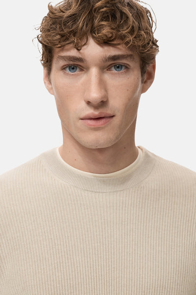 Beige ronde hals trui van MANGO, in ribgebreid, gedragen met een crèmekleurig T-shirt.