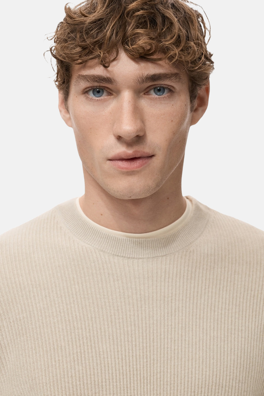 Beige ronde hals trui van MANGO, in ribgebreid, gedragen met een crèmekleurig T-shirt.