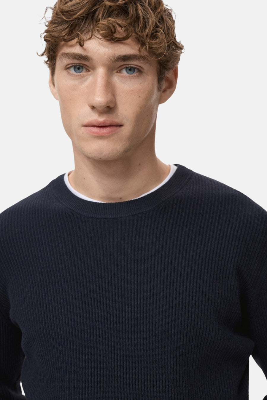 Blauwe trui met ronde hals van MANGO, in geribbelde breinaalden, gedragen met een wit T-shirt met ronde hals.