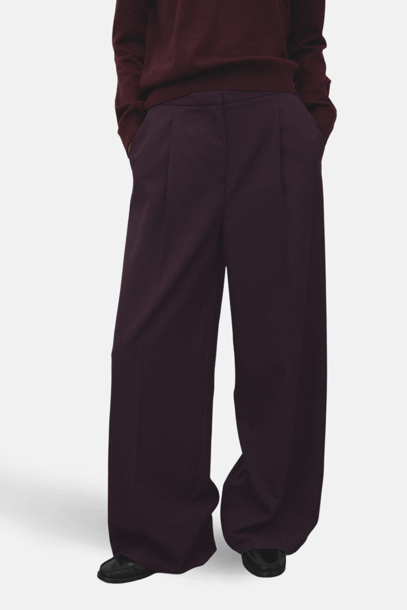 Pantalon bordeaux ample by MANGO, avec poches latérales et ourlets larges.