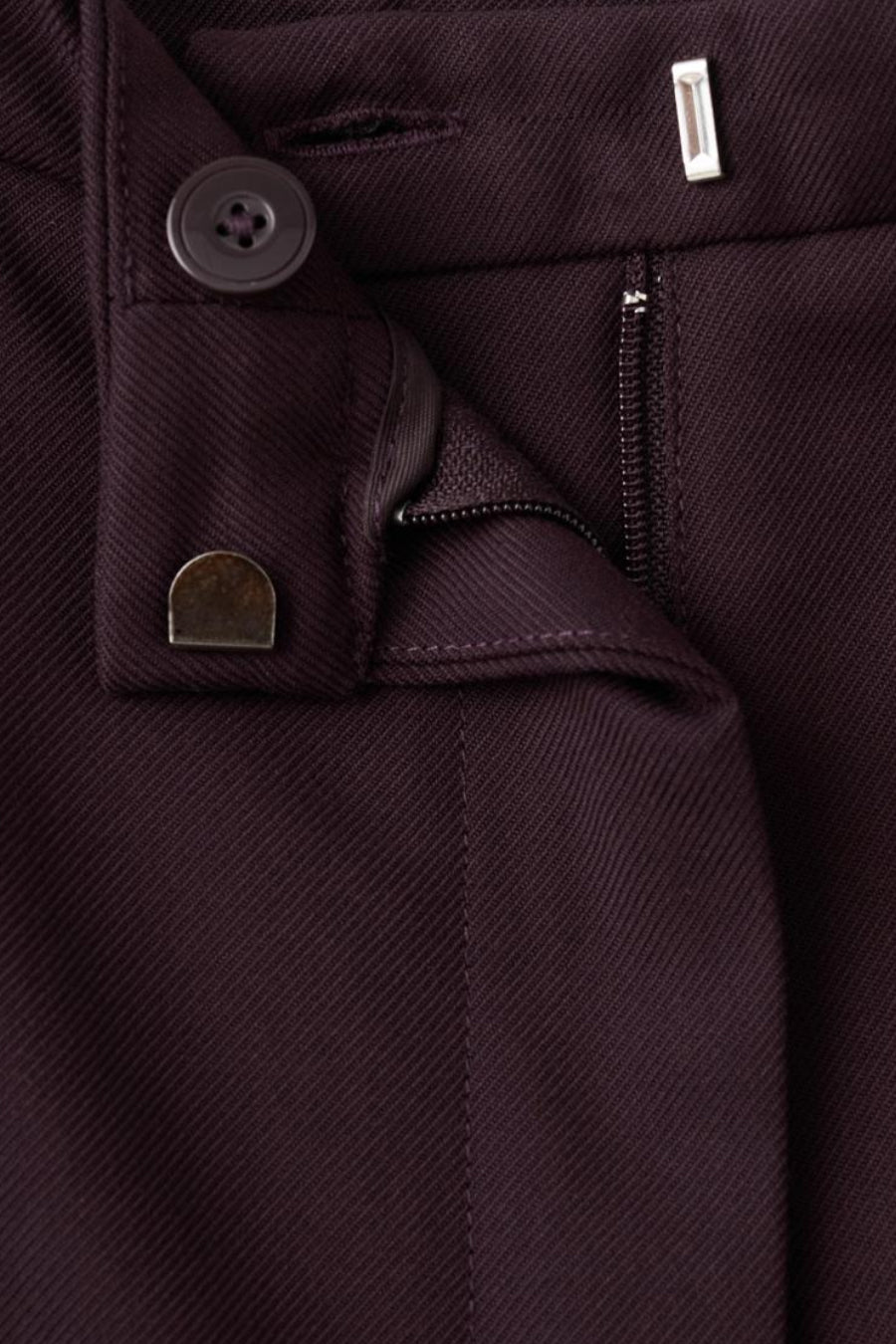 Pantalon bordeaux de MANGO avec fermeture éclair, bouton et agrafe métallique.
