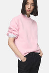 Roze trui met ronde hals van MANGO, gedragen met een zwarte jeans, van achteren gezien.