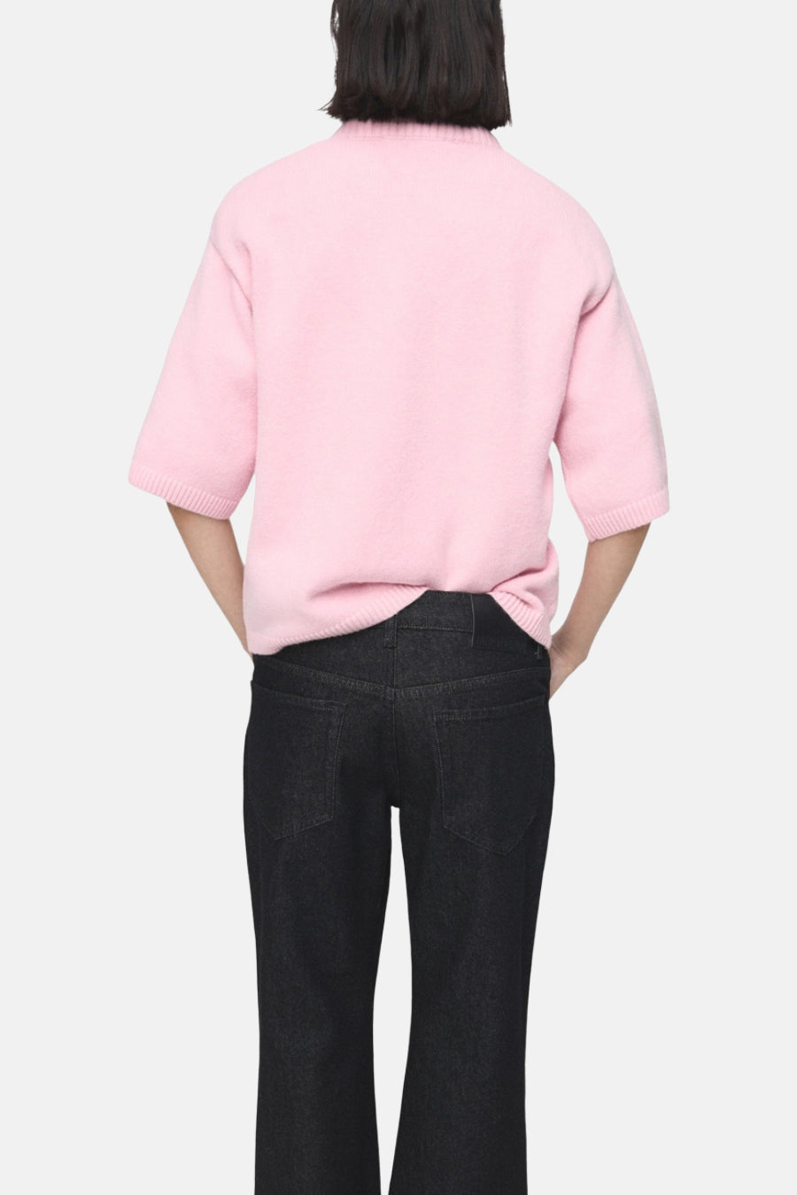 Pull rose à col rond de MANGO, porté avec un jean noir, vue de dos.
