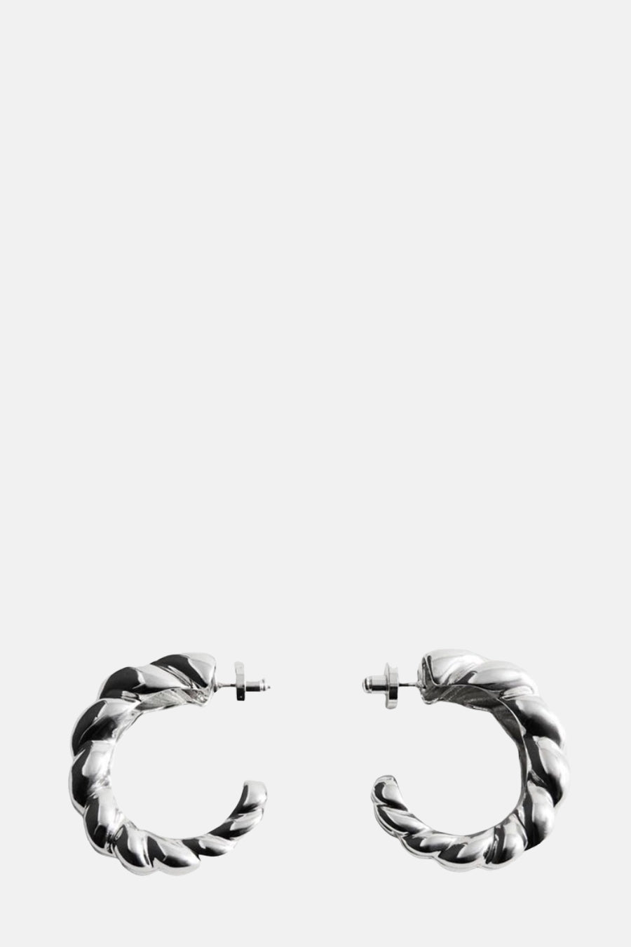 Boucles d'oreilles argentées torsadées de MANGO, montrant un motif tressé et une finition lisse et brillante.