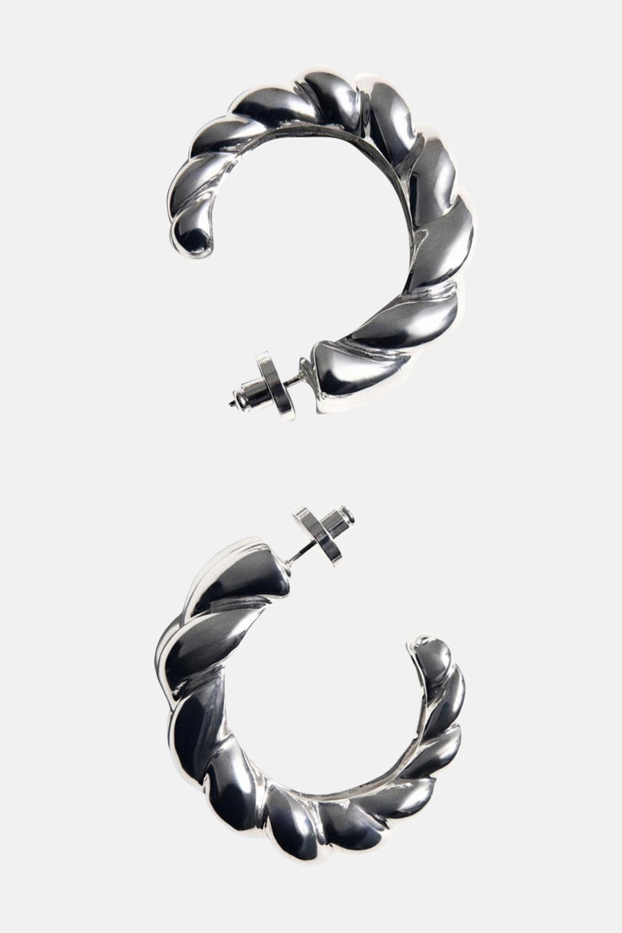 Boucles d'oreilles créoles argentées de MANGO, avec un motif torsadé et fermoirs à vis.