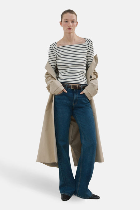 T-shirt à manches longues multicolore de MANGO, porté avec un manteau beige et un jean bleu.