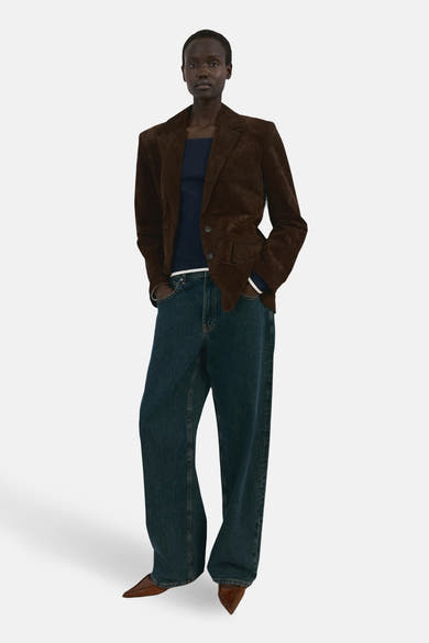 Blauwe T-shirt met lange mouwen van MANGO, gedragen met een bruine blazer en een wijde jeans.
