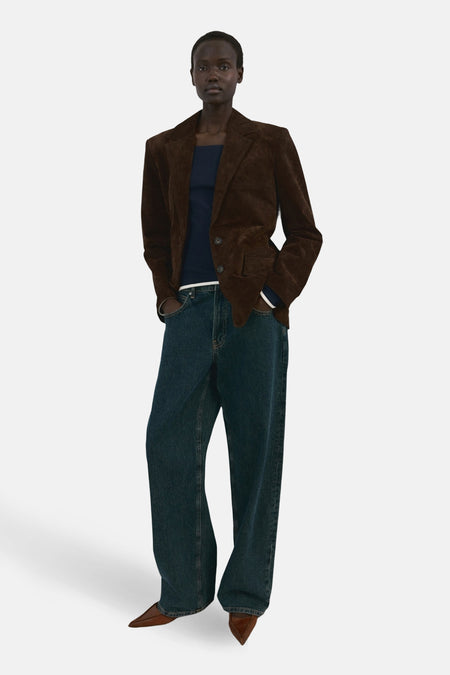 Blauwe T-shirt met lange mouwen van MANGO, gedragen met een bruine blazer en een wijde jeans.