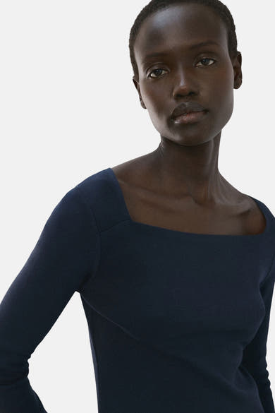 T-shirt à manches longues bleu de MANGO, coupe carrée, porté par un mannequin à peau foncée.