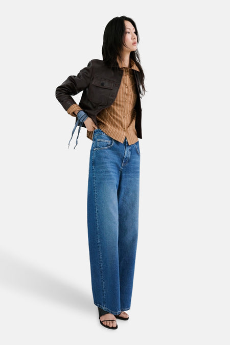 Chemise à manches longues marron rayée par MANGO, portée avec une veste en cuir et un jean taille haute.