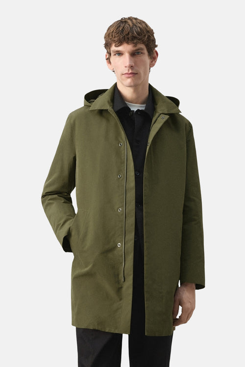 Veste longue kaki de MANGO avec capuche, patte de boutonnage, poches latérales et style décontracté.
