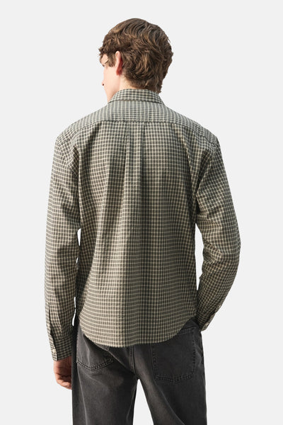 Chemise à manches longues multicolore de MANGO, motif à carreaux visible de dos, portée avec un jean gris.
